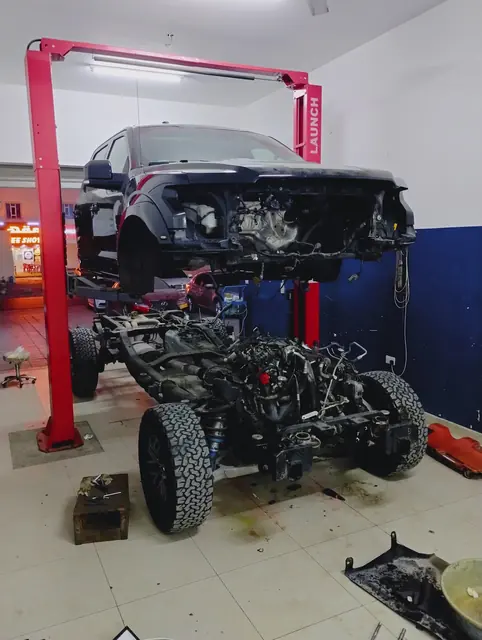 A 4x4 body lifted off its chassis during a rebuild
