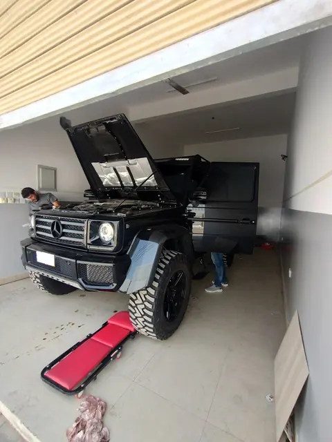 Mercedes-Benz G 500 4x4² with the bonnet open in a service bay