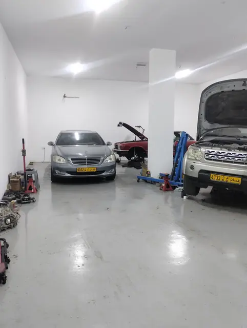 A Mercedes-Benz S-Class and a Land Rover Discovery in a service bay