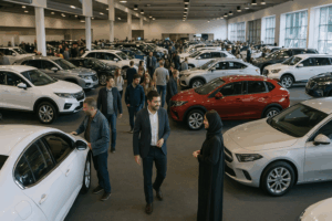 Crowds of visitors exploring cars at a busy automotive motor show in Oman, symbolising the dynamic market and importance of consulting in the automotive industry.